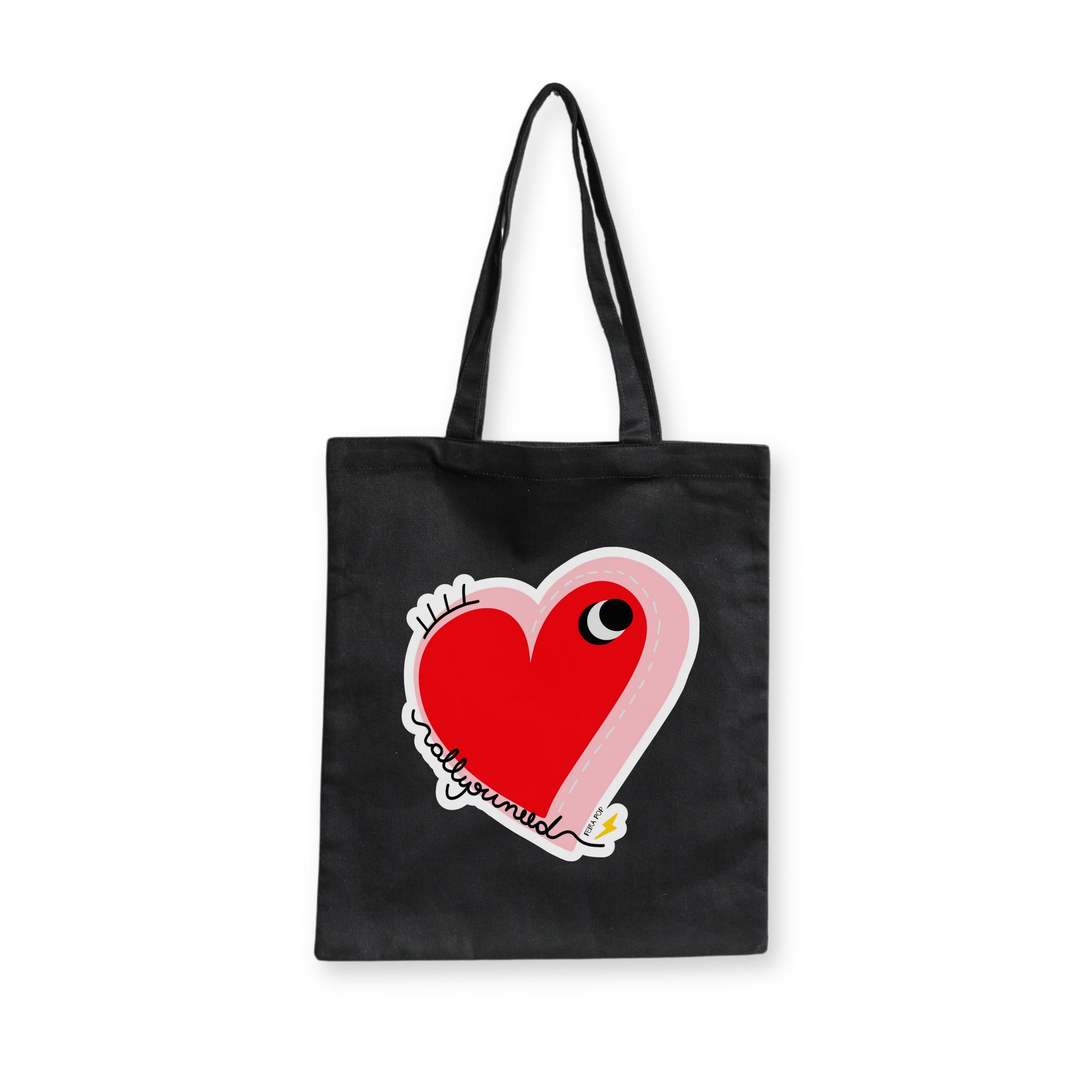 All You Need Tote Bag with original drawing of a big red heart with one eye and the words All You Need in playful font, perfect for carrying daily essentials and adding a touch of fun to any outfit.