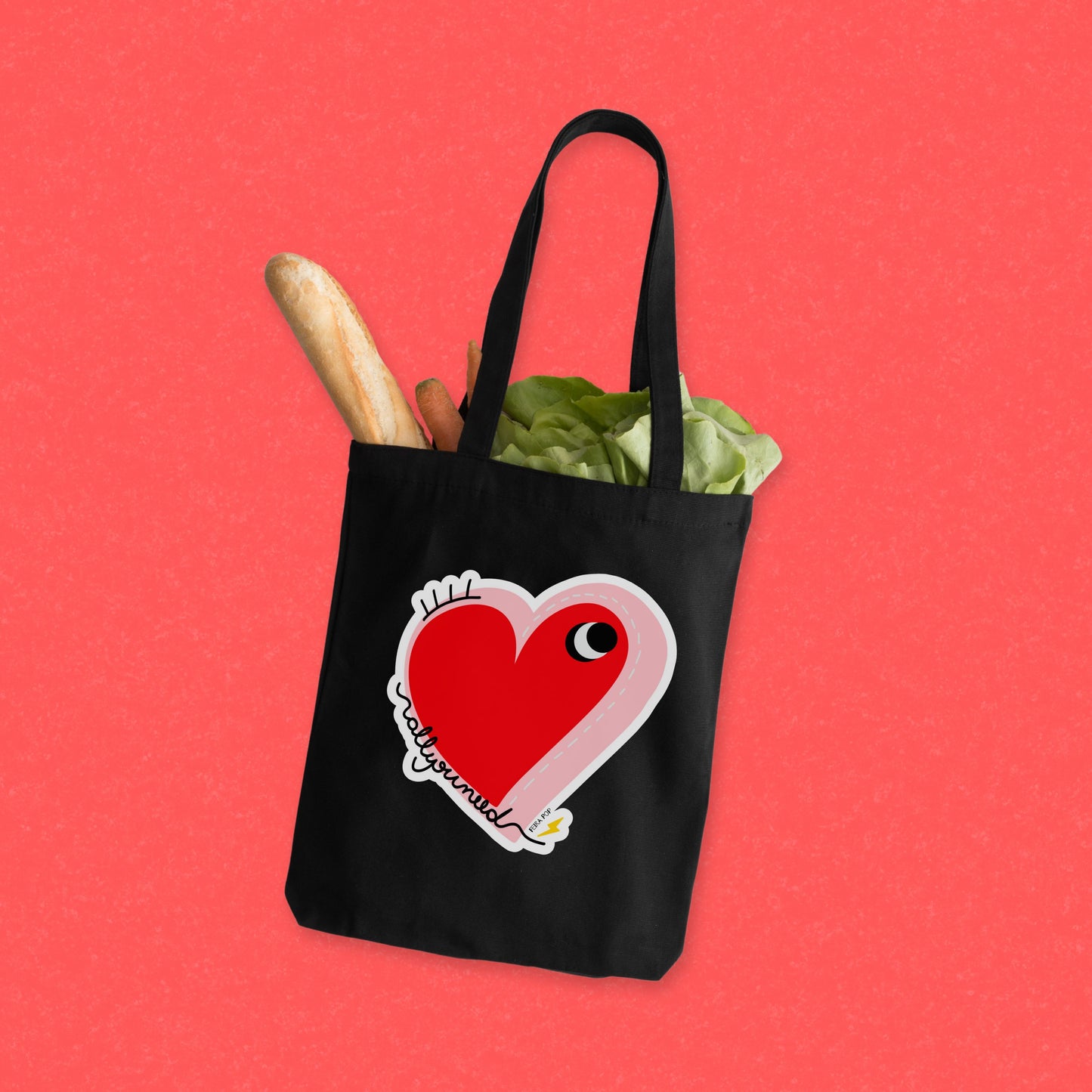 All You Need Tote Bag with original drawing of a big red heart with one eye and the words All You Need in playful font, perfect for carrying daily essentials and adding a touch of fun to any outfit.