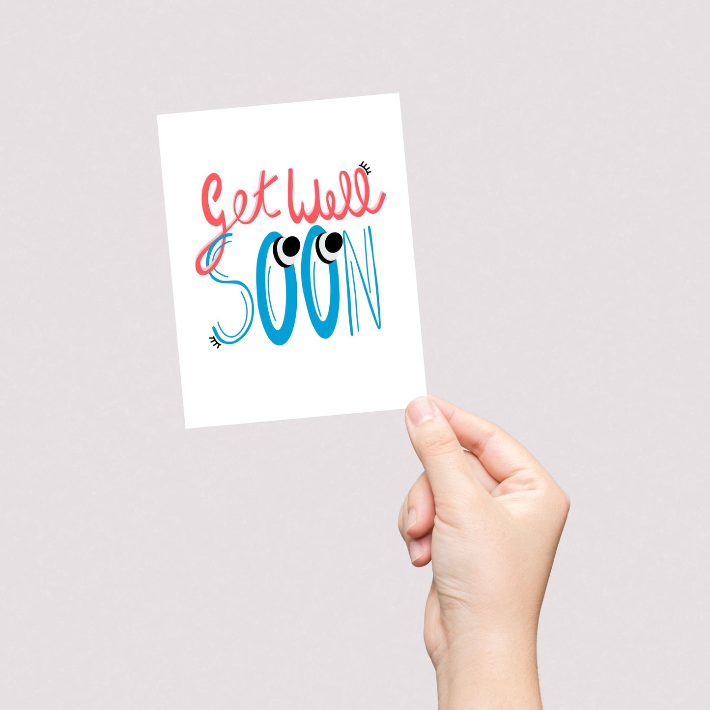 Greeting card with the phrase Get Well Soon featuring original lettering with two big googly eyes. Perfect for cheering up someone who is feeling under the weather with a playful and eye-catching touch.