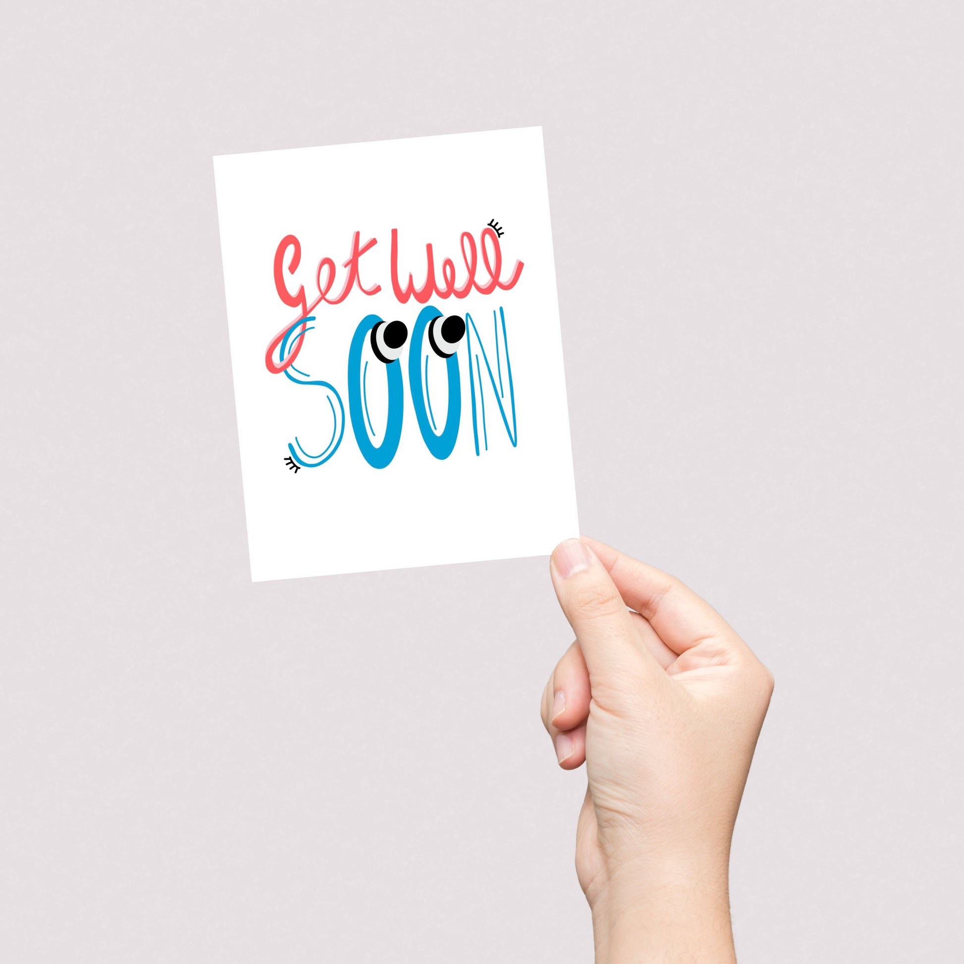 Greeting card with the phrase Get Well Soon featuring original lettering with two big googly eyes. Perfect for cheering up someone who is feeling under the weather with a playful and eye-catching touch.