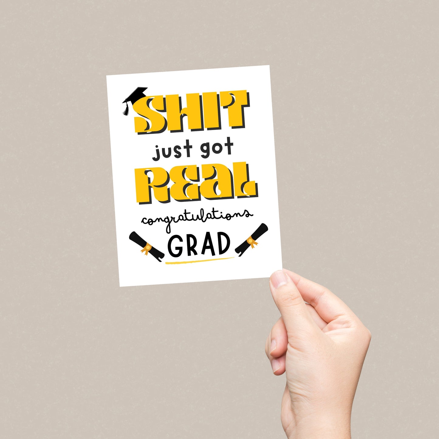 Funny graduation card with a black graduation cap, two rolled diplomas, and the phrase "Shit Just Got Real, Congratulations Grad" in bold letters. Perfect for high school or college graduates with a sense of humor.