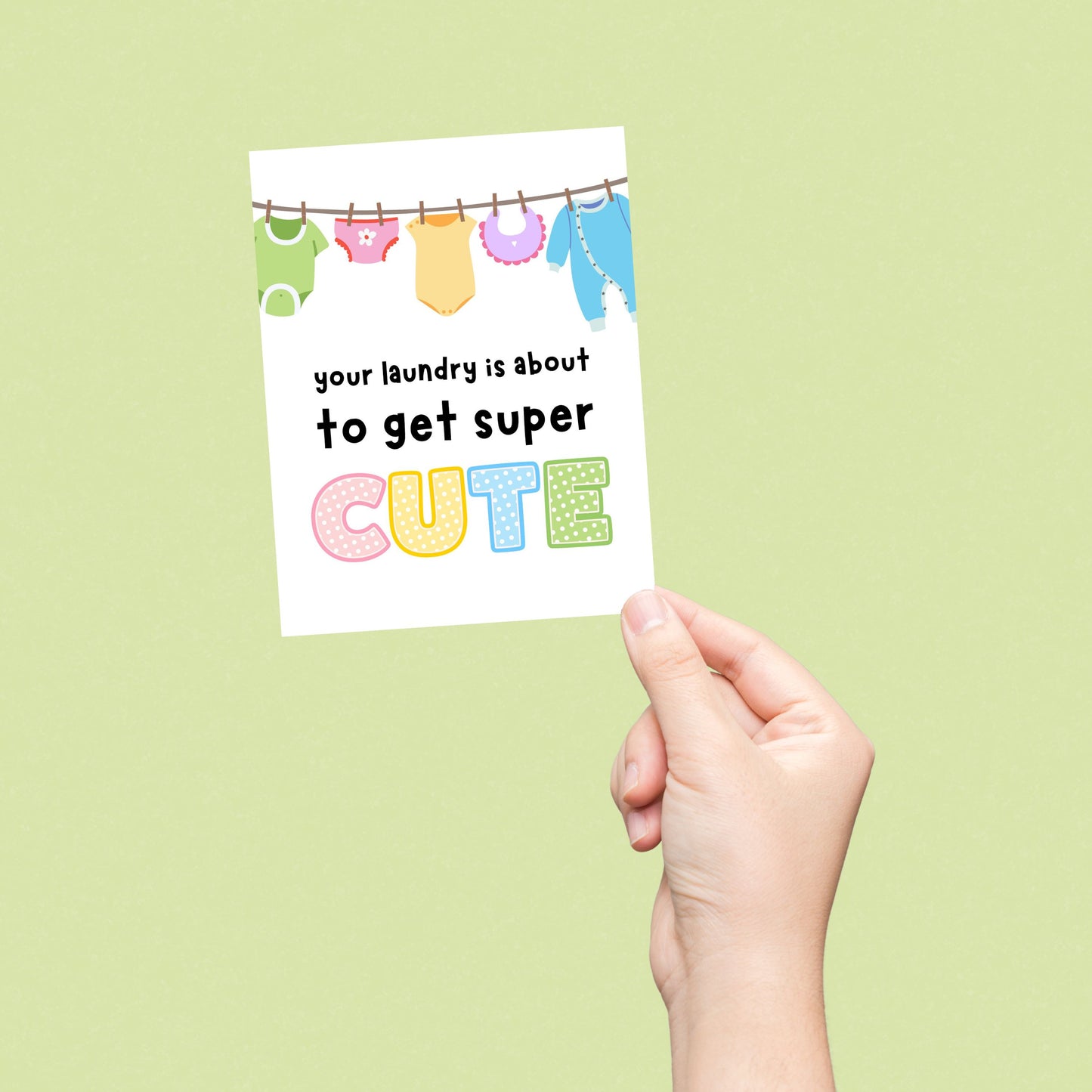 Funny new baby card with a clothesline full of cute baby clothes and the phrase "Your Laundry Is About To Get Super Cute," perfect for baby shower, pregnancy announcement, or new parent congratulations.