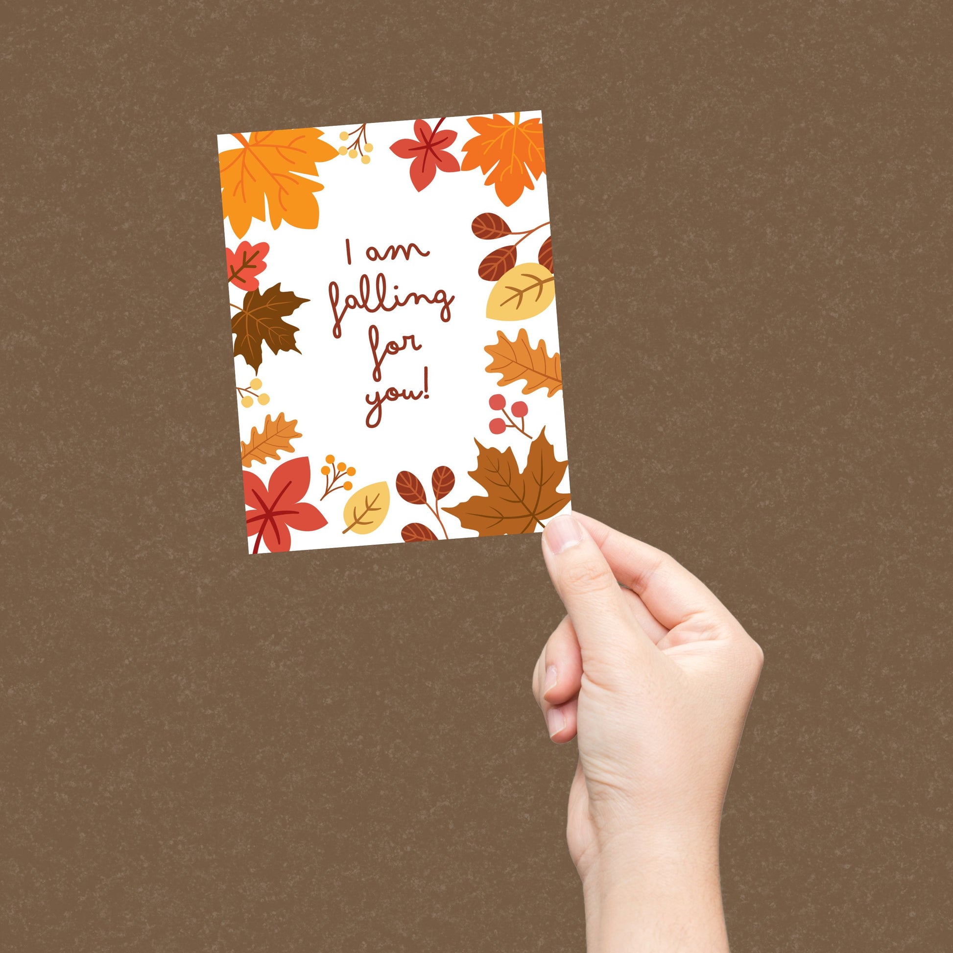 Greeting card with colorful fall leaves and the phrase 'I Am Falling For You' in bold letters. Perfect for expressing love and affection with a seasonal autumn theme. Ideal for romantic gestures or cozy fall greetings.