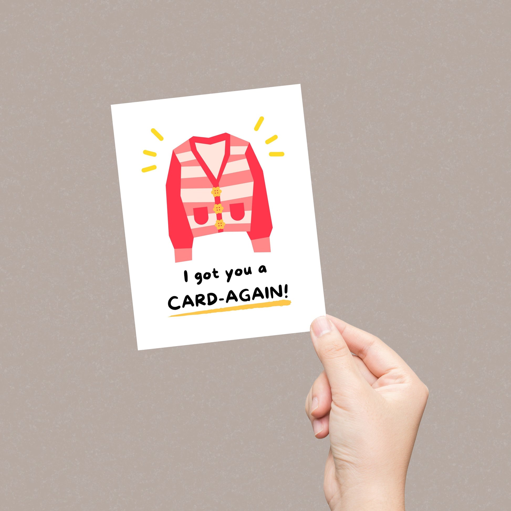 Cute greeting card featuring an illustration of a cozy cardigan with the punny phrase "I Got You A Card-Again." Perfect for birthdays, just-because moments, or to bring a smile with a clever play on words.