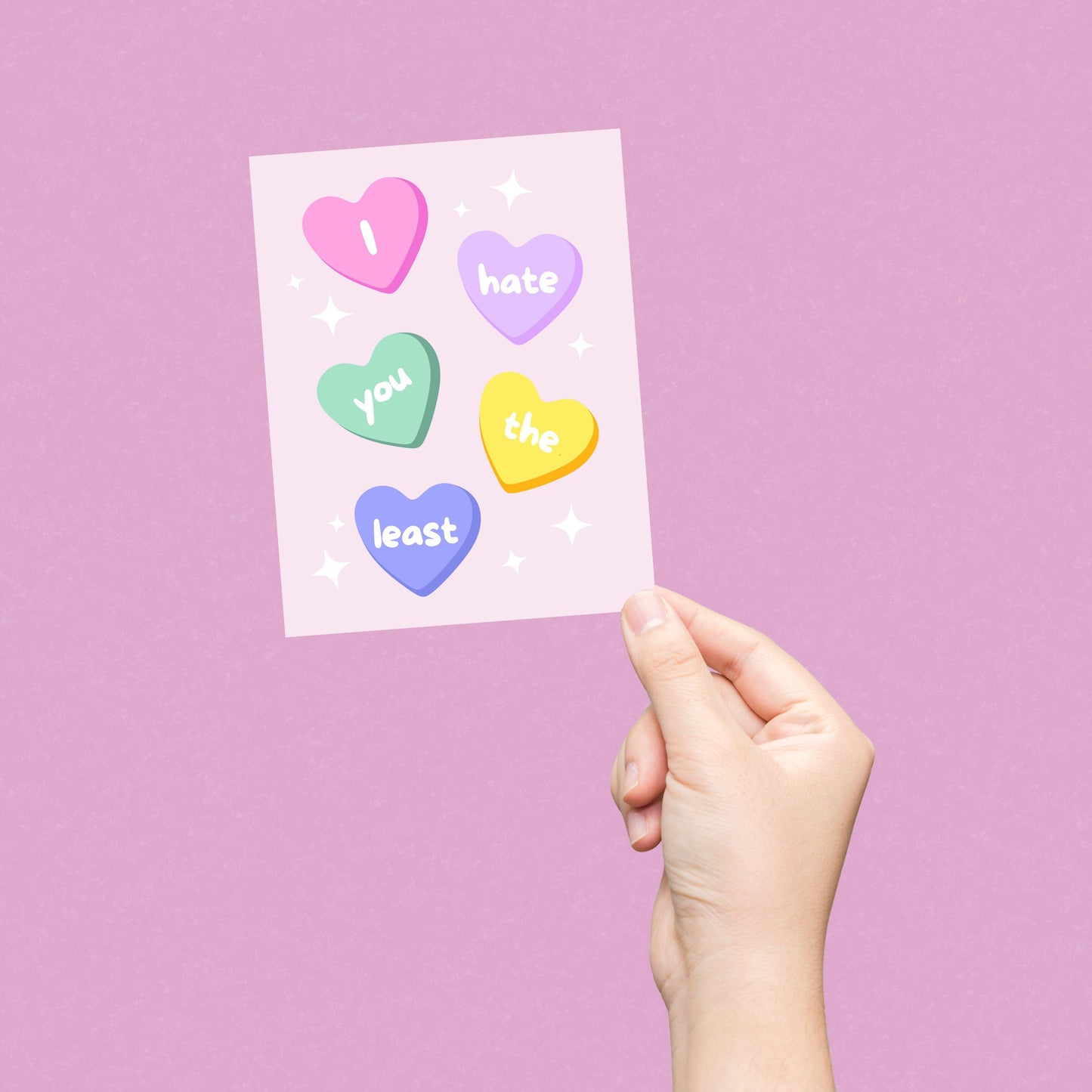 Funny greeting card with conversation heart candies, each displaying a word from the phrase 'I Hate You The Least.' Playful and humorous design perfect for Valentine's Day, friendships, or lighthearted occasions.