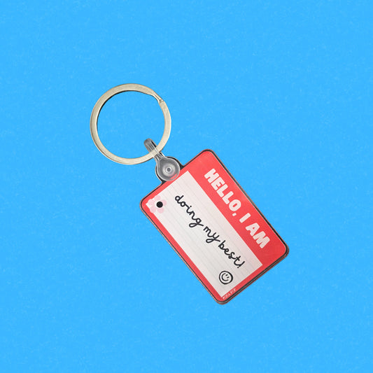 Red name tag keychain with the phrase Hello, I Am Doing My Best, humorous motivational accessory, perfect for daily encouragement and resilience, ideal gift for friends and family.