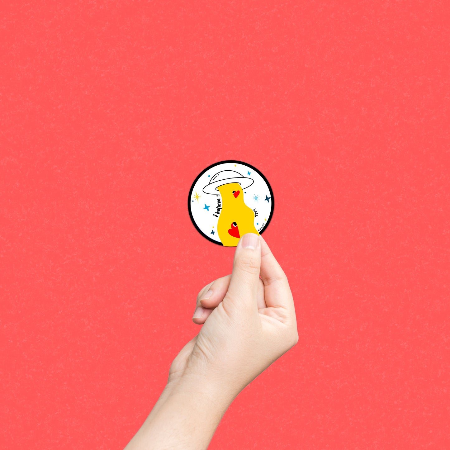 Sticker with the phrase I Believe featuring an original drawing of a UFO abducting two cute red hearts. Perfect for UFO enthusiasts and lovers of whimsical, romantic art.