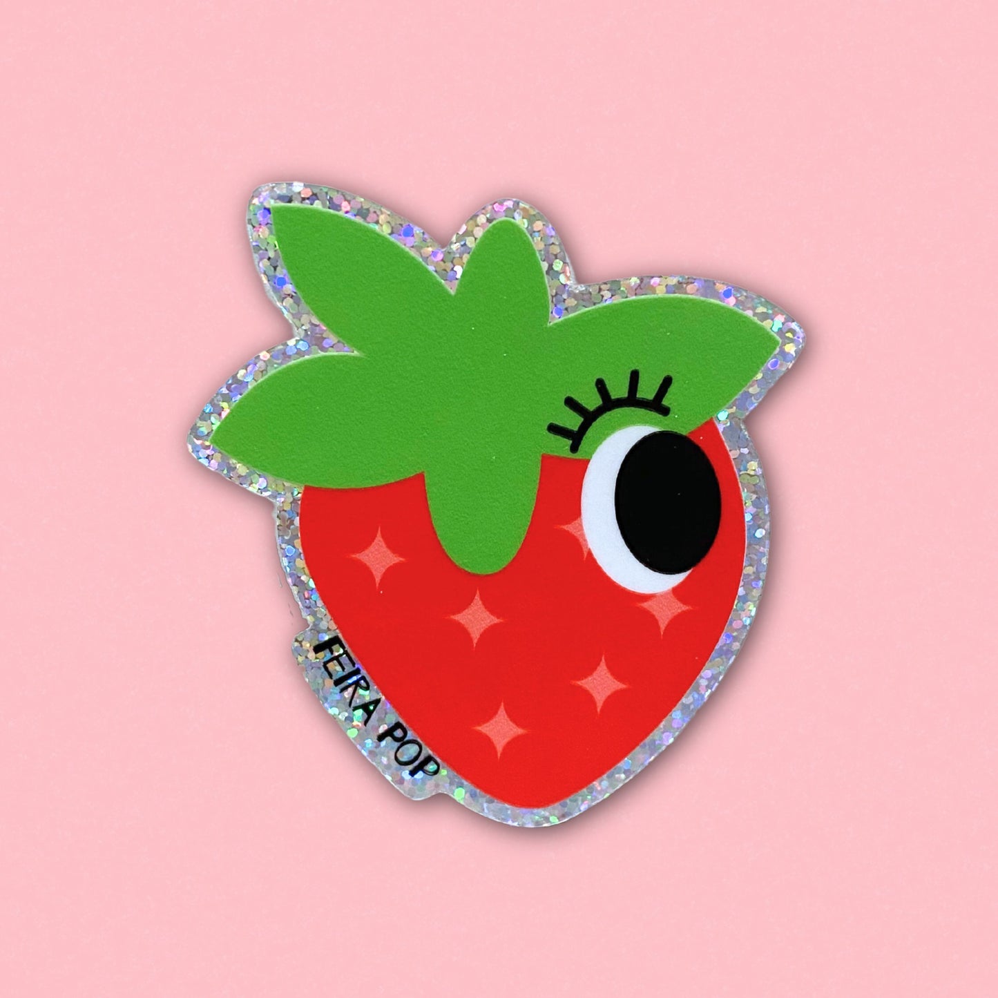 Glitter sticker with a cute strawberry drawing featuring one big eye, perfect for adding a playful and sparkly touch to your belongings.