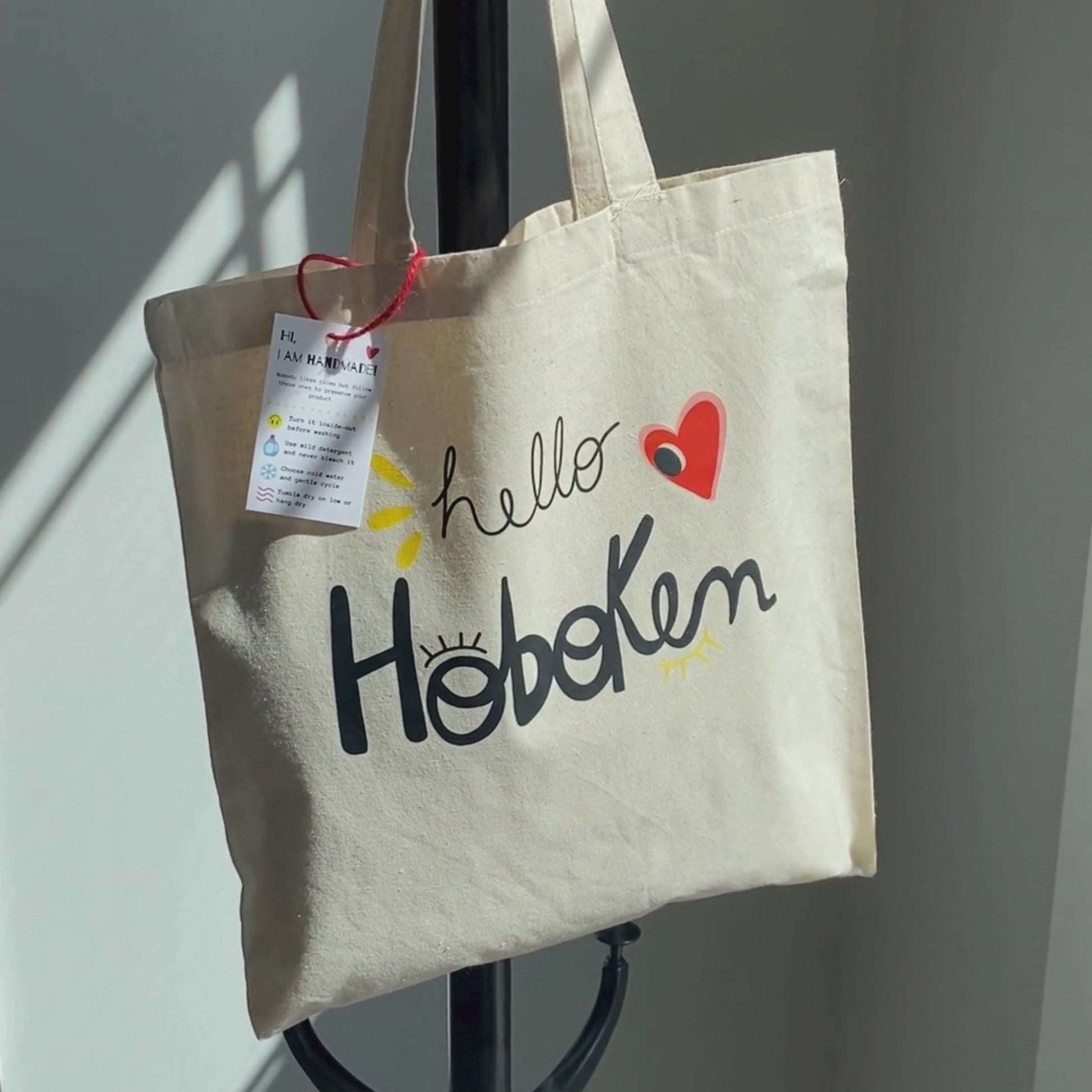 Tote bag with red heart and big eye design, called Hello Hoboken, representing Hoboken, New Jersey, perfect for stylish everyday use.