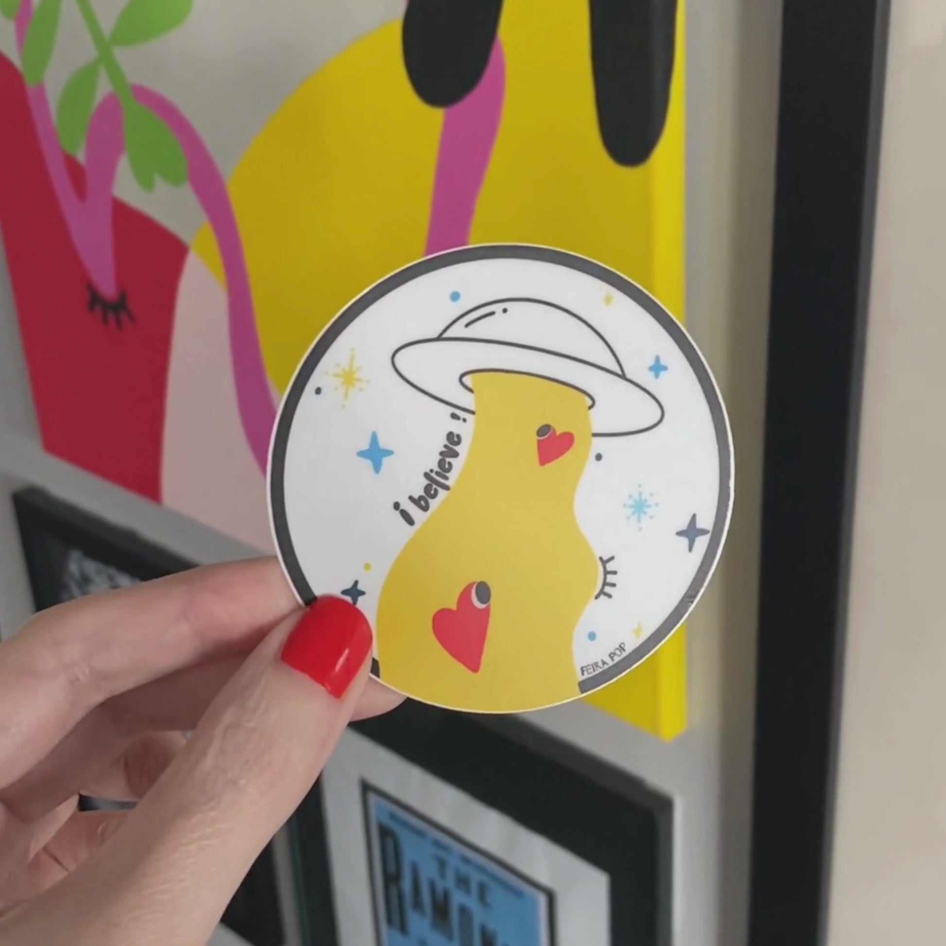 Sticker with the phrase I Believe featuring an original drawing of a UFO abducting two cute red hearts. Perfect for UFO enthusiasts and lovers of whimsical, romantic art.