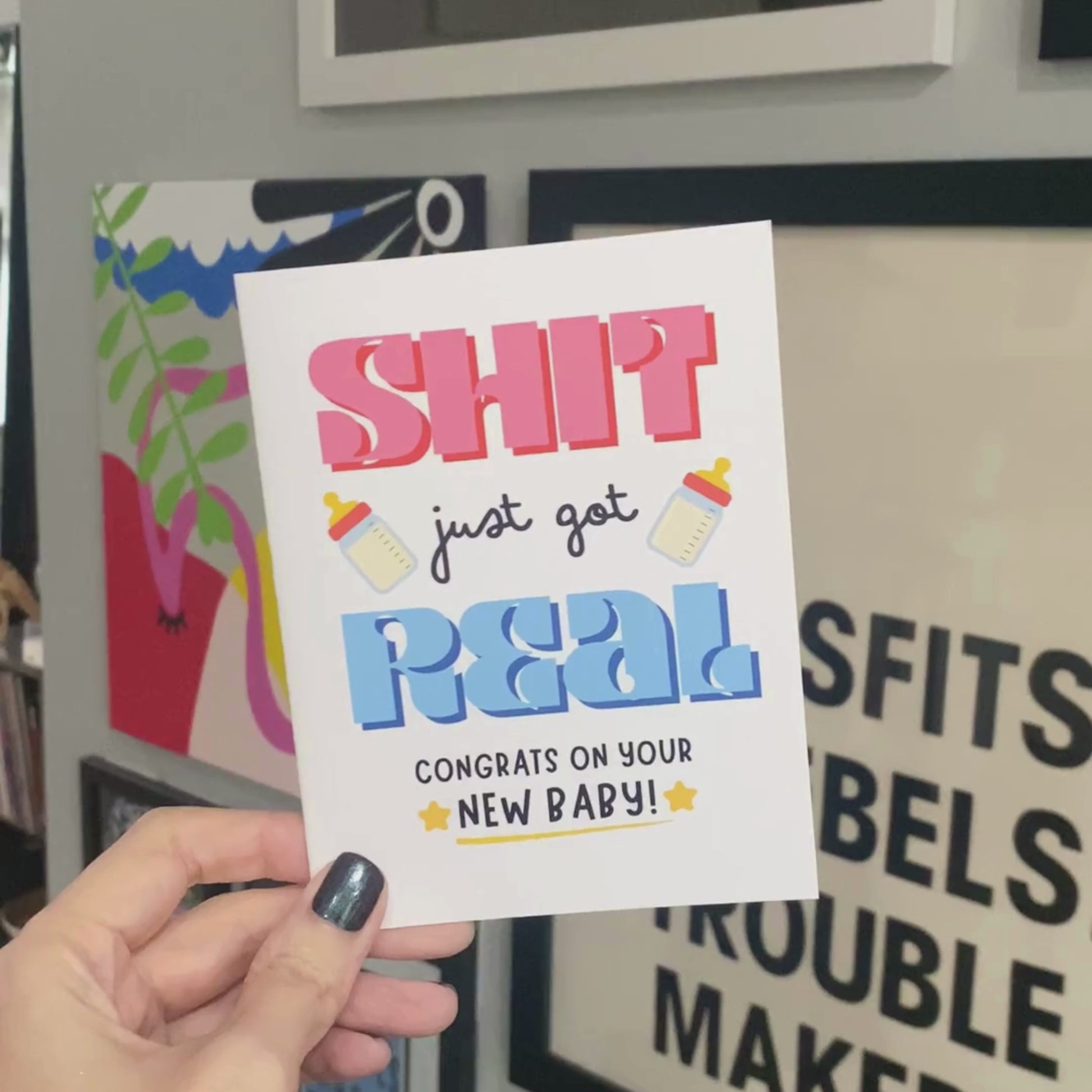 Funny new baby greeting card with bold letters, two baby bottles, and stars, featuring the phrase 'Sh*t Just Got Real Congrats On Your New Baby' for parents-to-be, baby showers, or newborn celebrations.