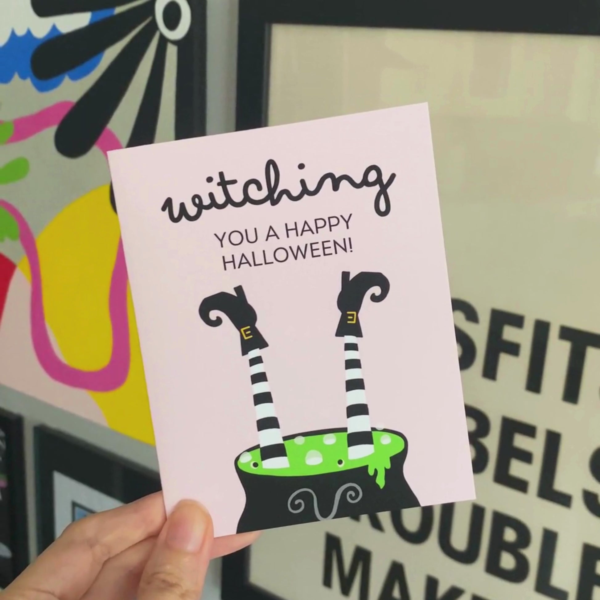 Halloween greeting card with a cauldron and two witch legs sticking out, featuring the phrase "Witching You A Happy Halloween," perfect for sending spooky and funny Halloween wishes.