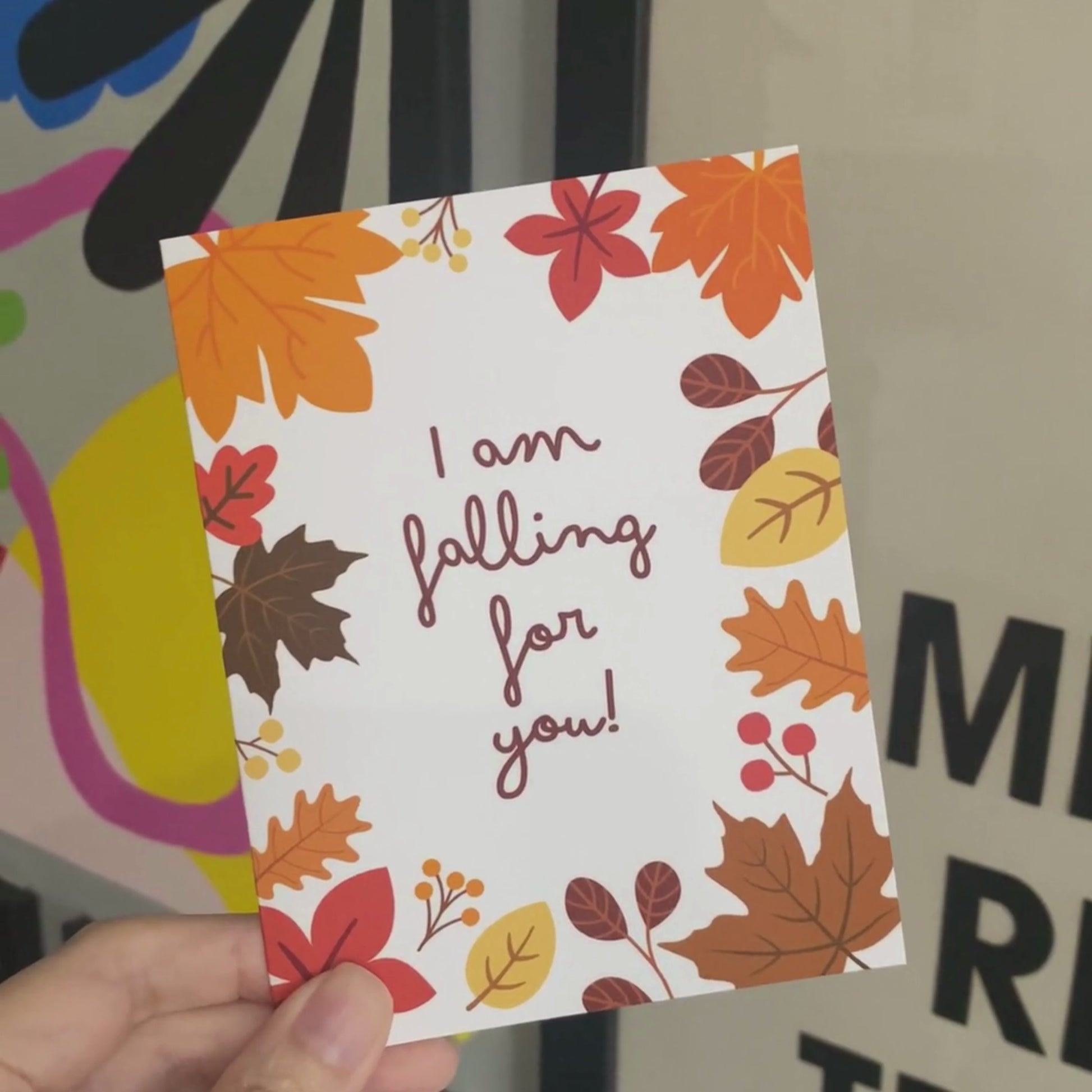 Greeting card with colorful fall leaves and the phrase 'I Am Falling For You' in bold letters. Perfect for expressing love and affection with a seasonal autumn theme. Ideal for romantic gestures or cozy fall greetings.