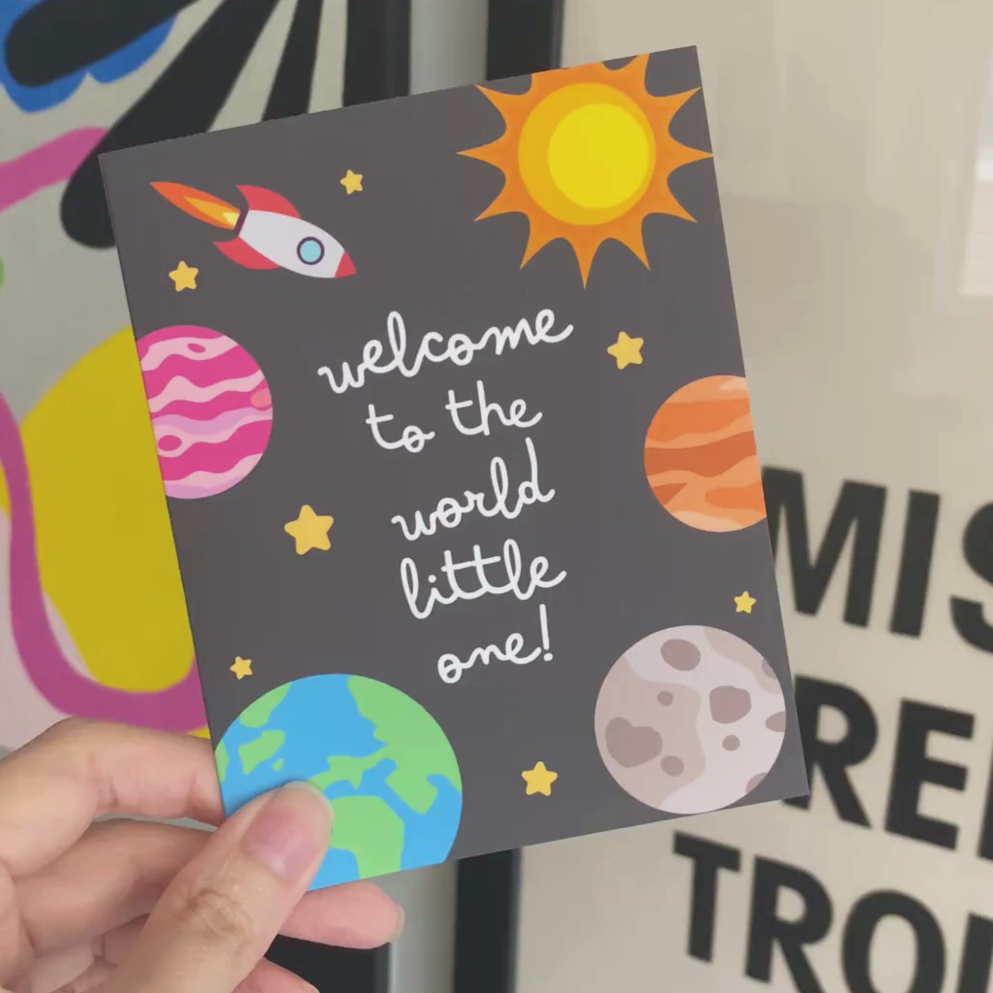 "Welcome to the World Little One" greeting card featuring cute hand-drawn planets and a rocket design, perfect for celebrating a newborn baby with a fun, space-themed touch. Ideal for baby showers, new parents, or welcoming a little astronaut.
