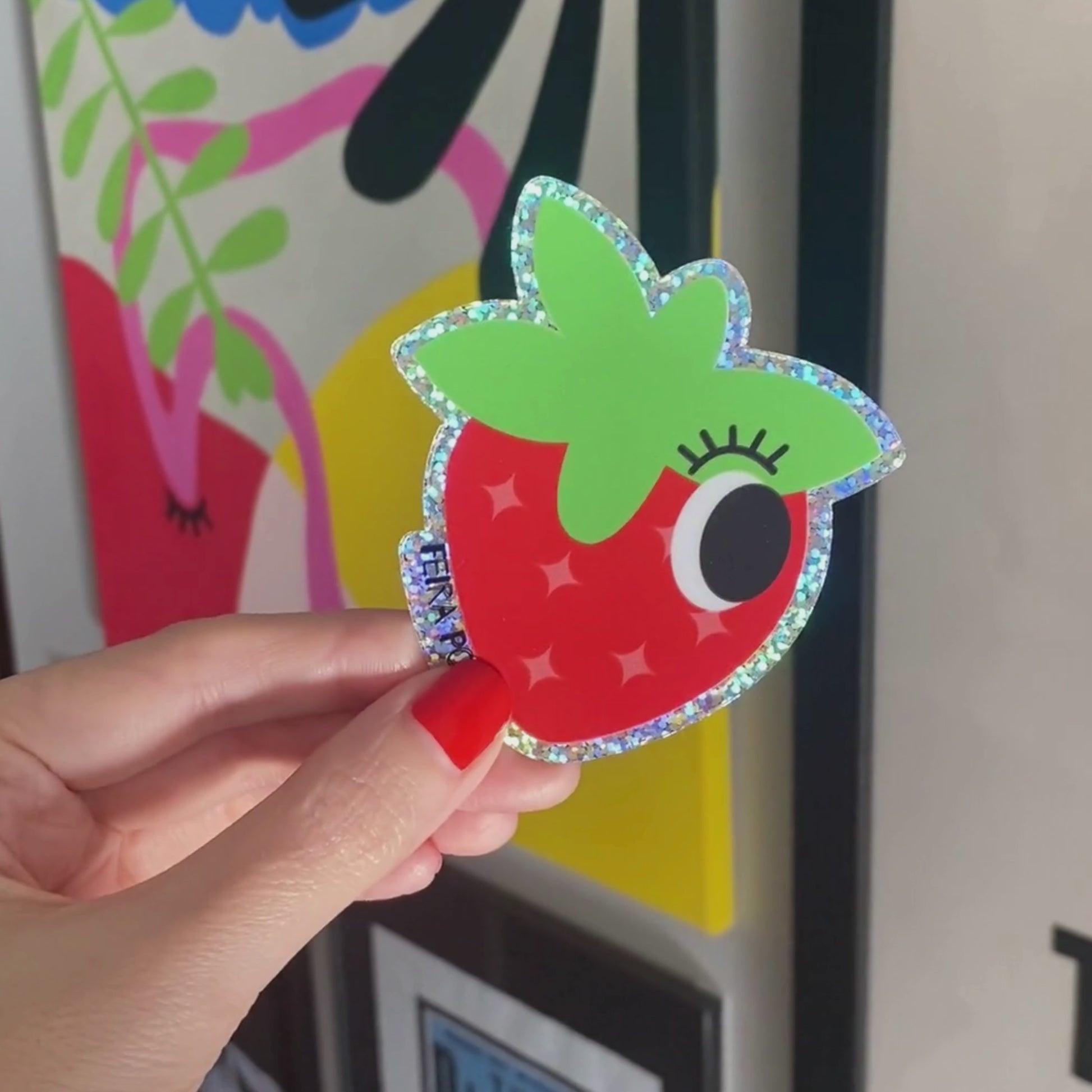 Glitter sticker with a cute strawberry drawing featuring one big eye, perfect for adding a playful and sparkly touch to your belongings.