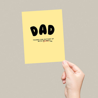 Greeting card with the phrase Dad, Thanks For Putting Up With My Shit in bold black letters on a yellow background. Perfect for showing appreciation to your dad with humor and heartfelt sentiment.