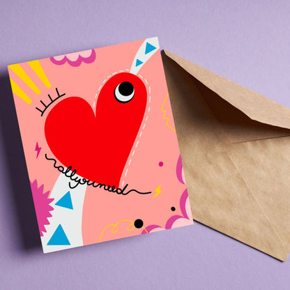 Greeting card with the phrase All you Need featuring a drawing of a big red heart with one eye and a colorful background. Perfect for celebrating any occasion with a playful and heartfelt touch.