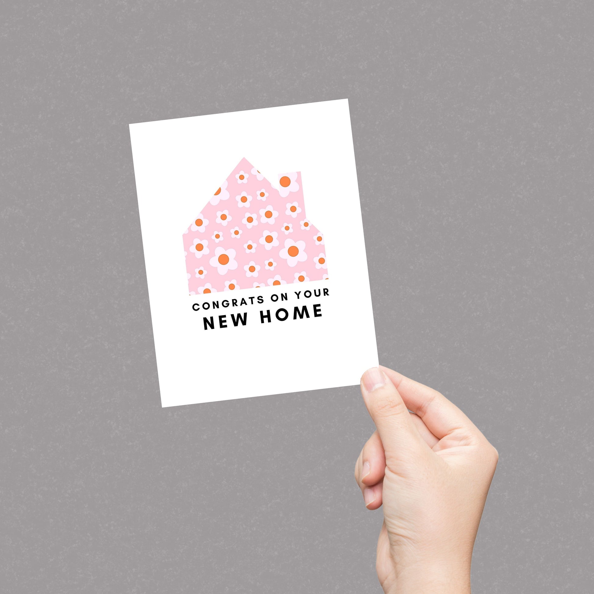 New home greeting card with a pink and white floral house design and the phrase "Congrats on Your New Home." Perfect for housewarming gifts, first-time homeowners, and moving celebrations. Ideal for real estate agents and thoughtful well-wishers.