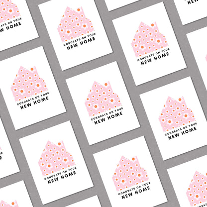 New home greeting card with a pink and white floral house design and the phrase "Congrats on Your New Home." Perfect for housewarming gifts, first-time homeowners, and moving celebrations. Ideal for real estate agents and thoughtful well-wishers.