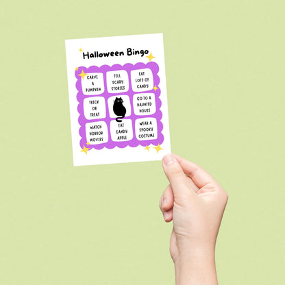 Halloween greeting card featuring a cute bingo card with spooky activities like spotting a black cat, visiting a haunted house, watching horror movies, and eating candy, perfect for Halloween enthusiasts who love festive fun.