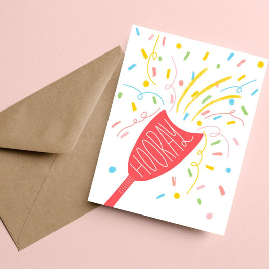 Greeting card with the word Hooray written in a party popper, featuring an original drawing of a party popper and colorful confetti flying out. Perfect for celebrating any joyous occasion with a festive and humorous touch.