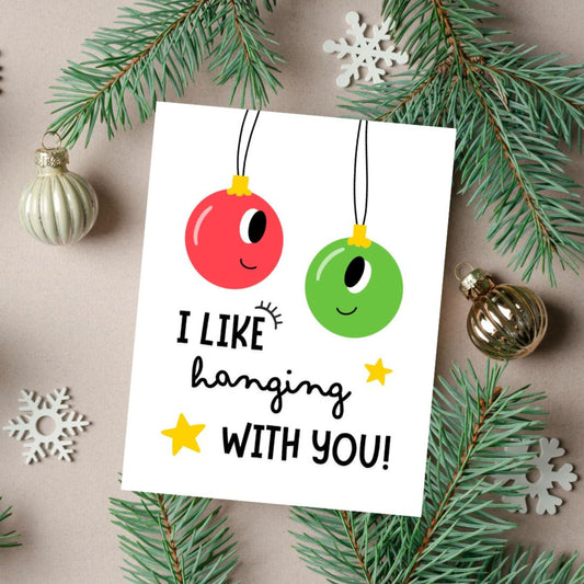 Christmas greeting card with two festive ornaments, one red and one green, and the playful phrase "I Like Hanging With You" in bold letters. Perfect for spreading holiday cheer, this funny card is ideal for friends, family, or loved ones.