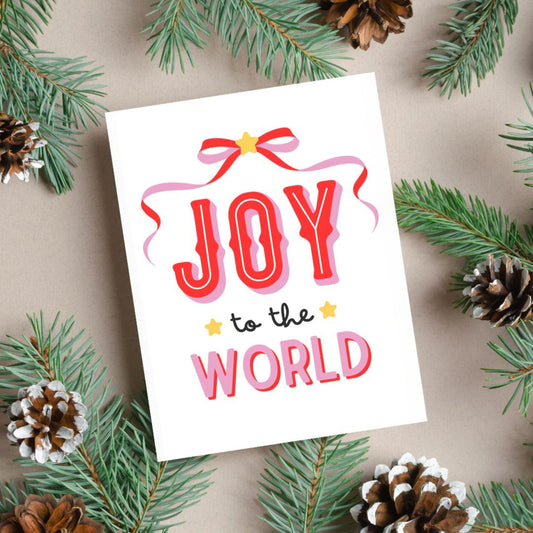 Christmas greeting card with a pink and red bow design, featuring the festive phrase Joy To The World in bold lettering, perfect for spreading holiday cheer with a fun and playful touch.