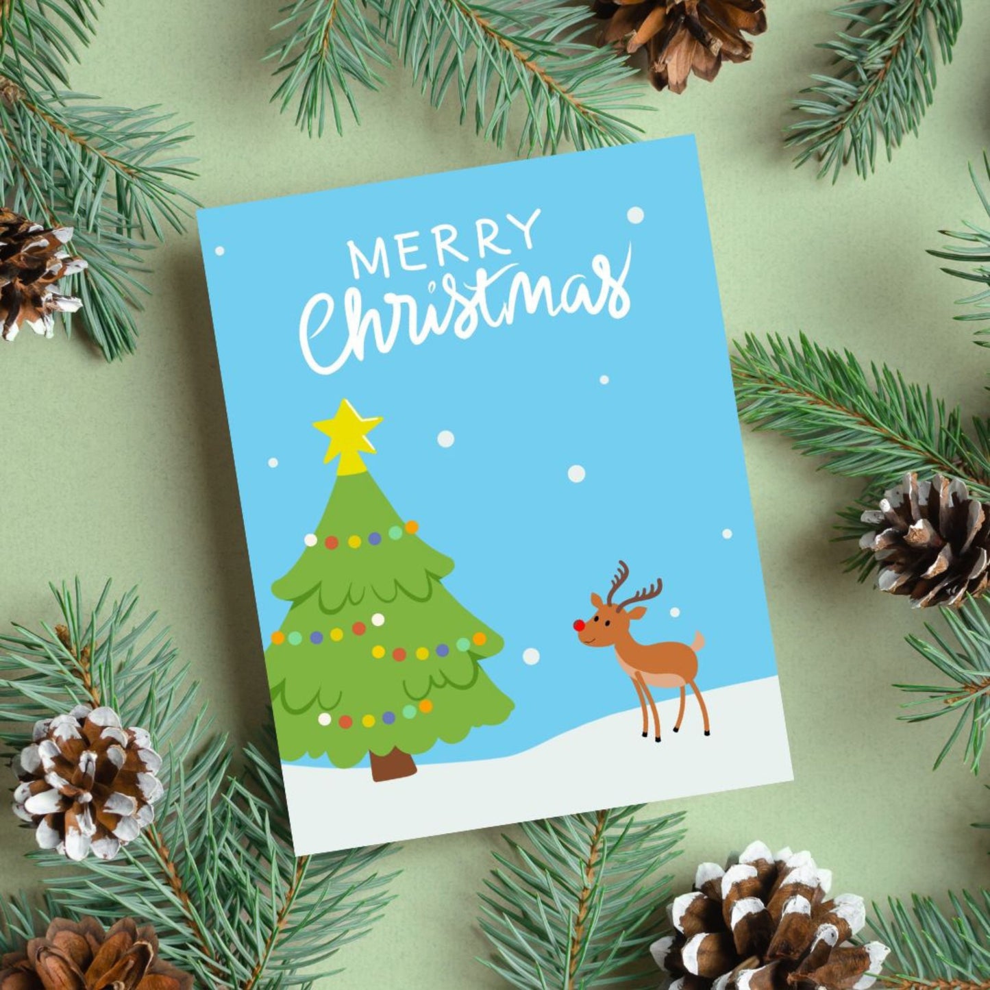 Christmas greeting card with a snowy landscape, decorated Christmas tree, and a cute red-Nosed Reindeer, featuring the phrase 'Merry Christmas' in bold letters, perfect for spreading festive cheer and holiday wishes.