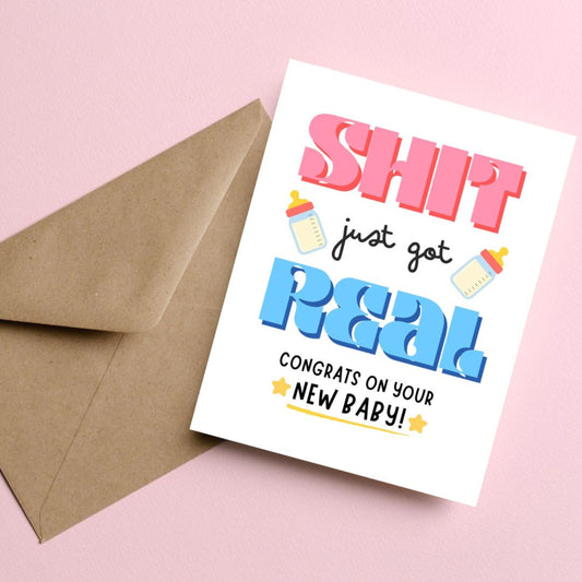 Funny new baby greeting card with bold letters, two baby bottles, and stars, featuring the phrase 'Sh*t Just Got Real Congrats On Your New Baby' for parents-to-be, baby showers, or newborn celebrations.