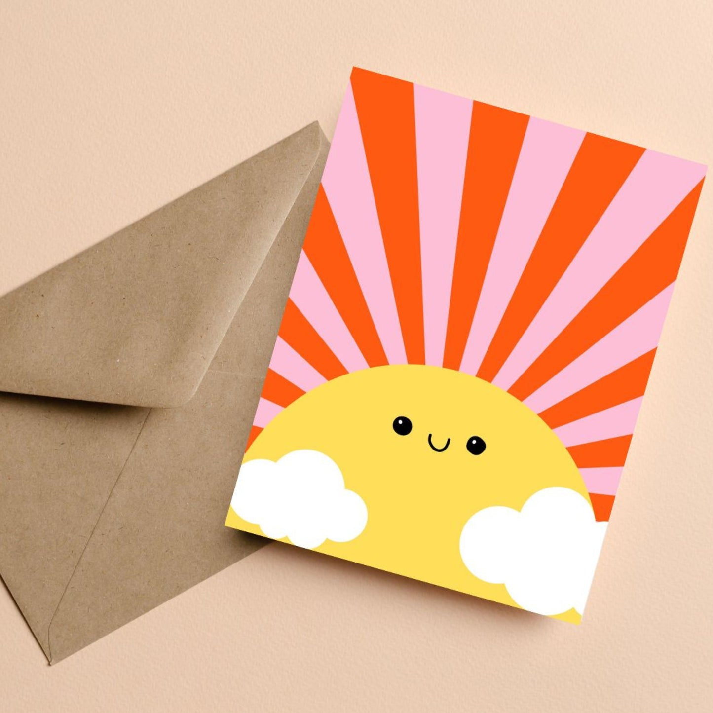 Sunshine Greeting Card with a drawing of a big yellow sun with a smiling face, pink and red rays, and two clouds. Blank inside, perfect for spreading cheerful vibes and warm wishes.