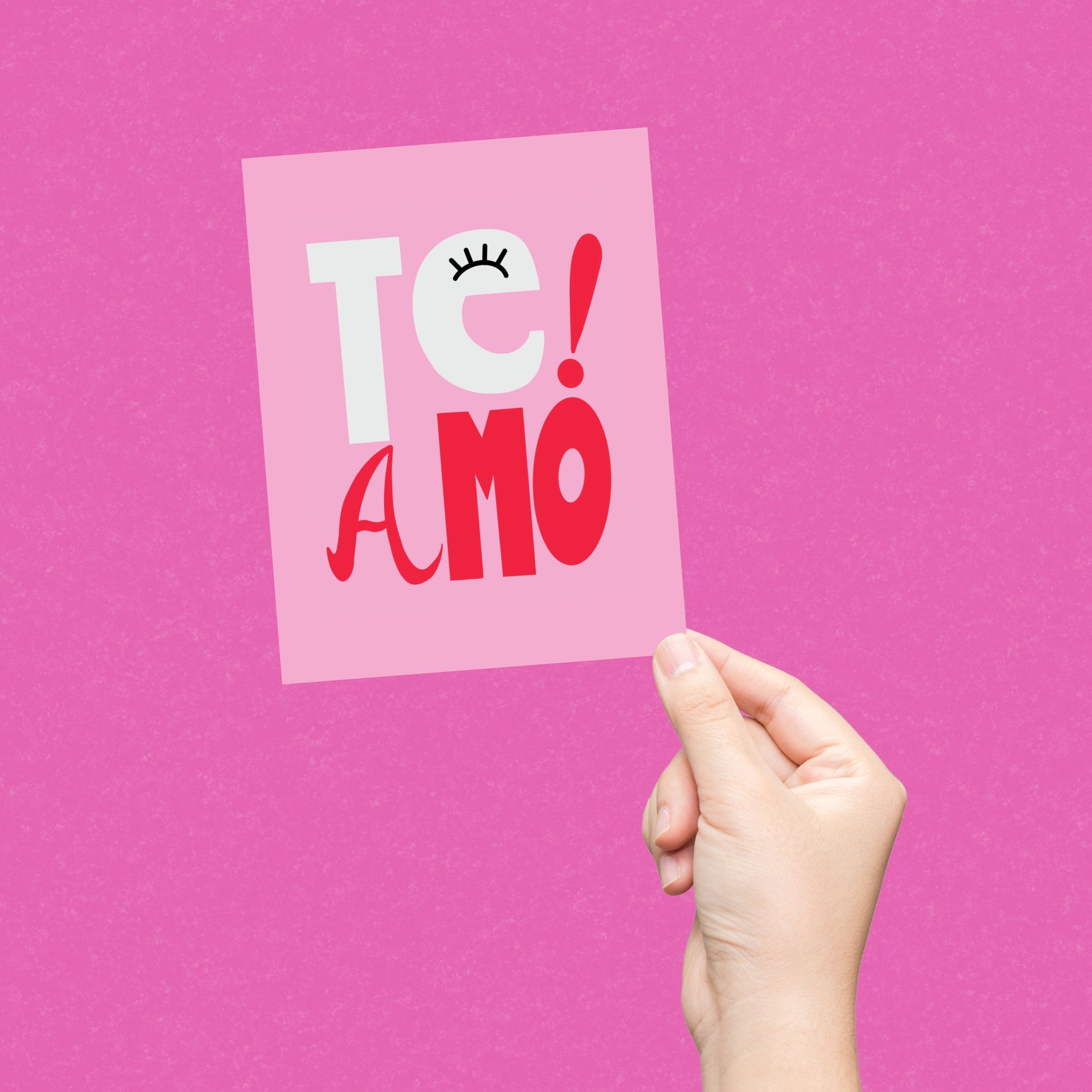 Te Amo greeting card with pink background, perfect for expressing love and affection, playful and whimsical design, ideal for anniversaries, special occasions, or just because, heartfelt and fun way to say "I love you" in Spanish and Portuguese.