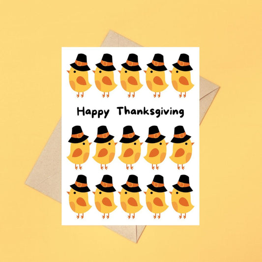 Cute Thanksgiving greeting card featuring adorable cartoon chicks wearing pilgrim hats with the phrase "Happy Thanksgiving" in bold. Perfect for spreading holiday cheer, humor, and festive vibes.