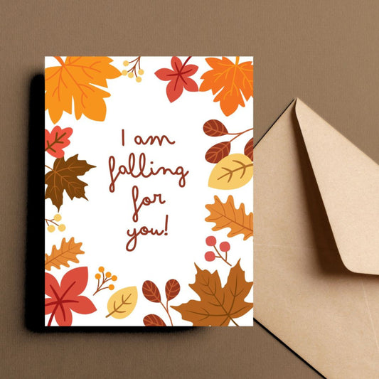 Greeting card with colorful fall leaves and the phrase 'I Am Falling For You' in bold letters. Perfect for expressing love and affection with a seasonal autumn theme. Ideal for romantic gestures or cozy fall greetings.