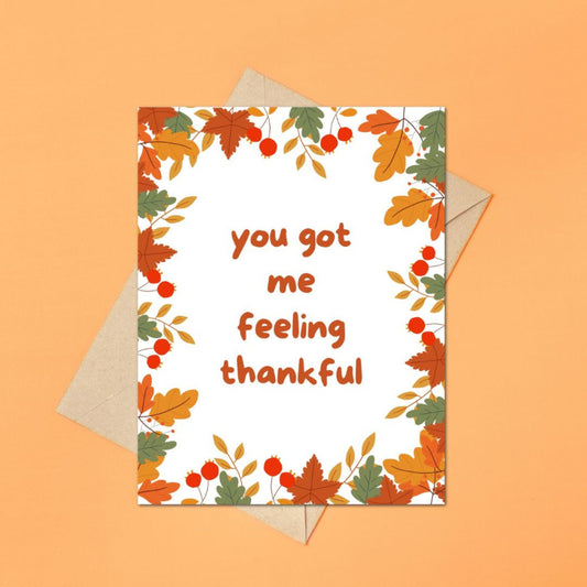 Greeting card with fall leaves surrounding the phrase 'You Got Me Feeling Thankful.' A perfect card for expressing gratitude during the autumn season, featuring vibrant autumn leaves and a playful message.