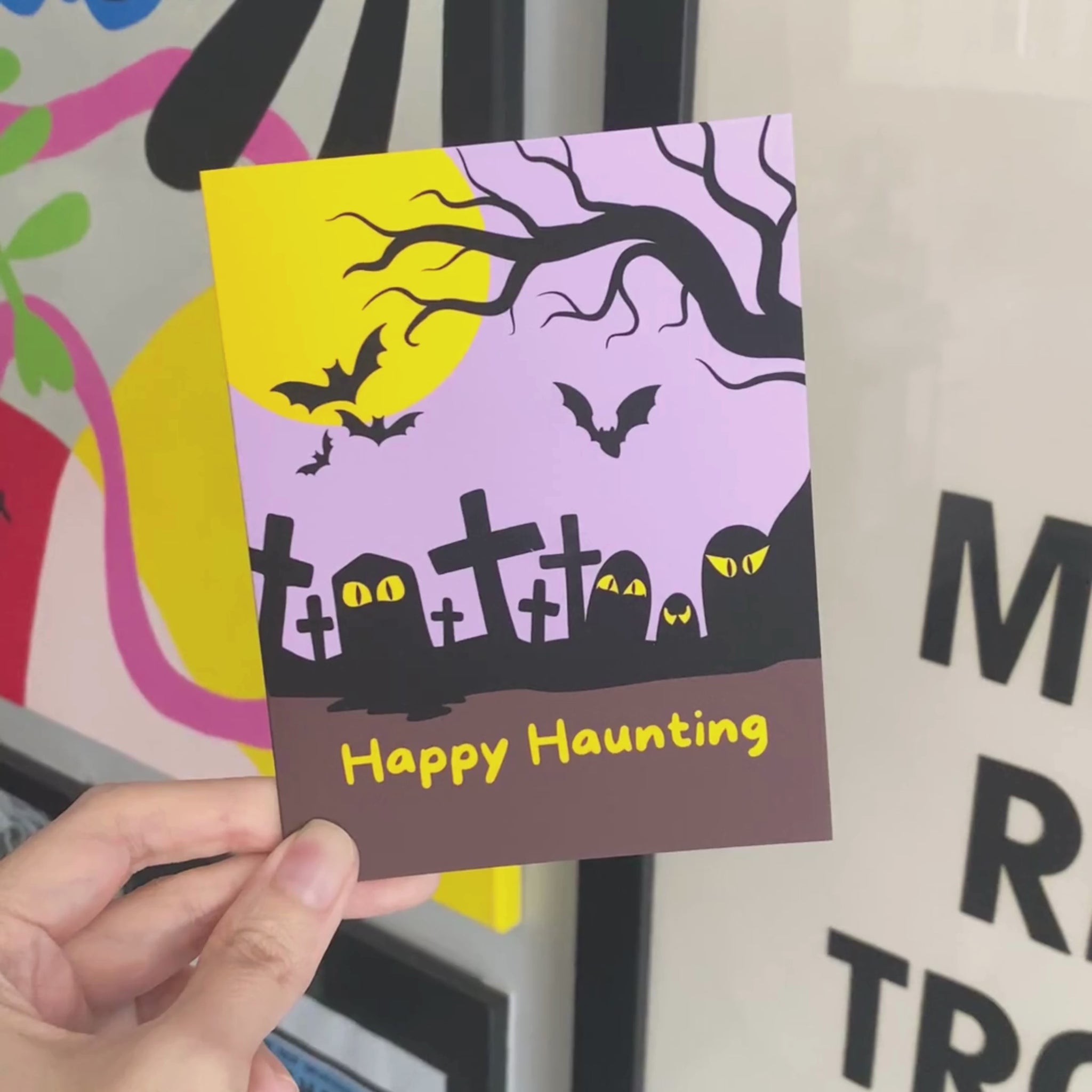 Halloween greeting card with a spooky cemetery illustration, tombstones, and a full moon, featuring the phrase Happy Haunting in bold letters. Perfect for sending Halloween wishes to friends and family.