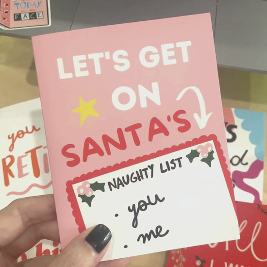 Let's Get On Santa's Naughty List Christmas card with a pink background, featuring Santa's Naughty List with you and me written on it. Perfect for a humorous and playful holiday greeting.