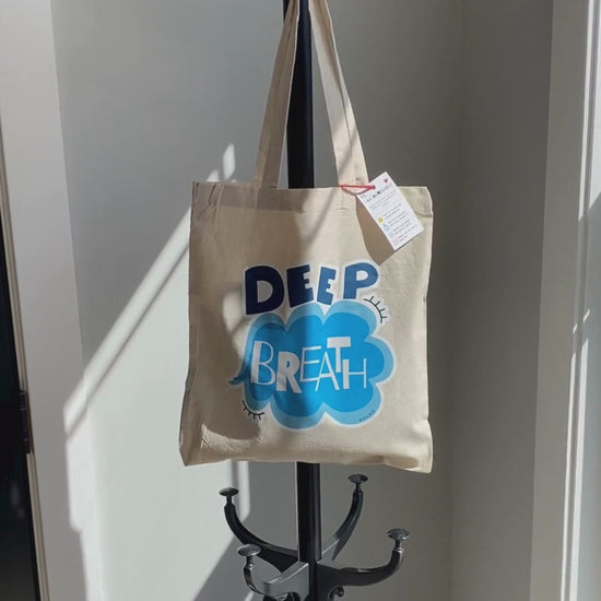 Deep Breath Tote Bag with original drawing of a serene cloud and the words Deep Breath written across it, perfect for carrying daily essentials and adding a touch of whimsy to your outfit.