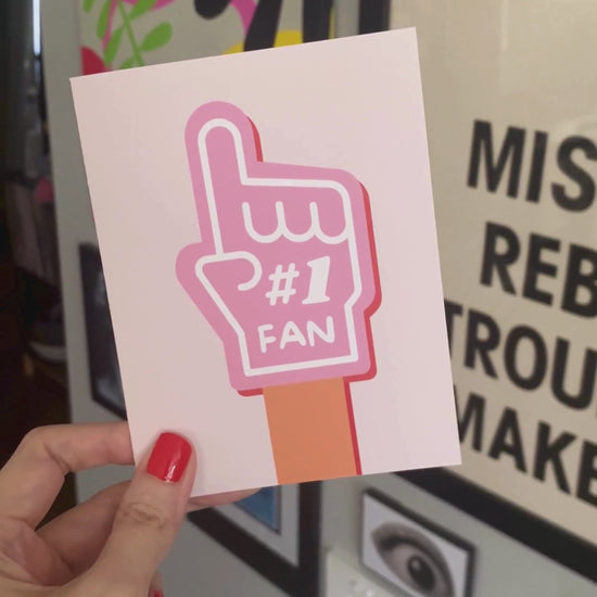 Greeting card with the phrase Number 1 Fan featuring a drawing of a pink foam hand with #1 Fan on it. Perfect for showing support and celebrating someone's awesomeness with cuteness and enthusiasm.